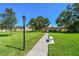 A serene, expansive green space with mature trees, manicured lawn, walking path, and seating at 5095 Bay Ne St # 114, St Petersburg, FL 33703