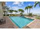 Community pool with lounge chairs and a dolphin fountain at 19820 Gulf Blvd # 401, Indian Shores, FL 33785