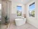 Bright bathroom with a freestanding tub, walk-in shower, and two large windows providing natural light at 135 48Th Ave, St Petersburg, FL 33703