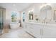 Luxurious bathroom featuring a soaking tub, dual vanity, and sleek fixtures at 135 48Th Ave, St Petersburg, FL 33703