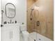 Modern bathroom showcases a glass shower with wood-look tile and a sleek vanity with black hardware at 135 48Th Ave, St Petersburg, FL 33703