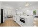 Bright, open kitchen featuring a large island, white cabinets, dining area, and modern appliances at 135 48Th Ave, St Petersburg, FL 33703