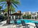 Community pool with lounge chairs, umbrellas, and a cabana at 2511 N Grady Ave # 53, Tampa, FL 33607