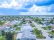 An aerial view showcasing a single-story house with a light gray roof in a residential area at 3543 Seffner Dr, Holiday, FL 34691