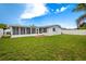 Large backyard with grassy lawn and screened patio at 3543 Seffner Dr, Holiday, FL 34691