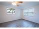 Well-lit bedroom with grey wood-look flooring and large windows at 3543 Seffner Dr, Holiday, FL 34691