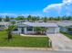 Single-story home with white exterior, blue trim, and a well-maintained lawn at 3543 Seffner Dr, Holiday, FL 34691
