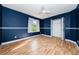 Bedroom with dark blue walls, wood floors, and ceiling fan at 957 Westwinds Blvd, Tarpon Springs, FL 34689