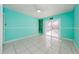 Bedroom with light teal walls, tile floors, and sliding glass doors at 957 Westwinds Blvd, Tarpon Springs, FL 34689