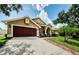 Beautiful single-story home with a two-car garage, manicured lawn, and a welcoming front porch with pillars at 957 Westwinds Blvd, Tarpon Springs, FL 34689