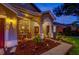 Home exterior at dusk with an inviting front porch and manicured landscaping at 957 Westwinds Blvd, Tarpon Springs, FL 34689