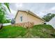 Rear view of home with a screened-in patio and stone foundation at 957 Westwinds Blvd, Tarpon Springs, FL 34689