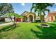 Charming one-story home with a manicured front lawn and mature palm trees at 957 Westwinds Blvd, Tarpon Springs, FL 34689