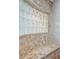 Tiled shower features a glass block window and a built-in bench at 957 Westwinds Blvd, Tarpon Springs, FL 34689