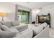 Spacious living room with gray sectional sofa and access to backyard at 2926 Suncoast Plains Dr, Odessa, FL 33556