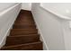 Modern staircase with dark wood steps and white railings at 2926 Suncoast Plains Dr, Odessa, FL 33556