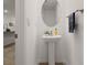 Small powder room with pedestal sink and oval mirror at 2926 Suncoast Plains Dr, Odessa, FL 33556