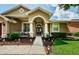 Tan two story home with a decorative front entry at 957 Westwinds Blvd, Tarpon Springs, FL 34689