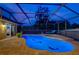 Luminous night view of a screened pool and spa with dolphin accents at 957 Westwinds Blvd, Tarpon Springs, FL 34689