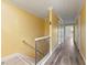 Hallway with wood floors and white trim leading to bedrooms with closets and a window at 1768 Lago Vista, Palm Harbor, FL 34685