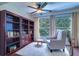 Relaxing sunroom with comfortable armchair, built-in shelving, and large windows at 1655 S Highland Ave # B216, Clearwater, FL 33756