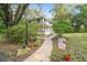 House exterior showcasing a walkway to the front porch, surrounded by lush landscaping at 2327 Spring Lake Hwy, Brooksville, FL 34602