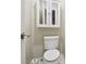 Small bathroom with a toilet and a wall-mounted cabinet at 2327 Spring Lake Hwy, Brooksville, FL 34602