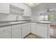 White kitchen with gray countertops, dishwasher, and tile floor at 5080 Locust Ne St # 329, St Petersburg, FL 33703