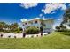 Two-story home with white exterior, landscaping, and a paved driveway at 13064 Via Flavia, Placida, FL 33946