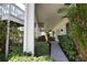 Covered walkway leading to the home's entrance, surrounded by tropical plants at 13064 Via Flavia, Placida, FL 33946