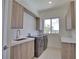 Modern laundry room with washer, dryer, and ample cabinetry at 13064 Via Flavia, Placida, FL 33946