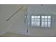 Modern white staircase with glass railing overlooking living room at 13064 Via Flavia, Placida, FL 33946