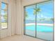 Bedroom with sliding glass doors showcasing a pool and canal view at 1884 Dolphin S Blvd, St Petersburg, FL 33707