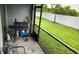 Screened-in patio with grilling area and view of grassy backyard at 7643 Ginger Lily Ct, Tampa, FL 33619