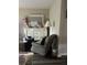 Main bedroom with dresser, seating area, and large mirror at 7643 Ginger Lily Ct, Tampa, FL 33619