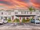 Townhomes with gray siding, red doors, and covered parking; sunset view at 2745 Enterprise E Rd # 24, Clearwater, FL 33759