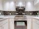 Kitchen with white cabinets, mosaic backsplash, and stainless steel appliances at 2745 Enterprise E Rd # 24, Clearwater, FL 33759