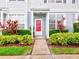Townhouse with red front door, landscaping, and walkway at 2745 Enterprise E Rd # 24, Clearwater, FL 33759