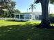 Landscaped backyard with large tree and view of the water at 501 20Th Ave, Indian Rocks Beach, FL 33785