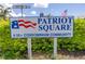 Sign for Patriot Square, a 55+ condominium community with well-maintained landscaping at 4115 34Th S Way # 195, St Petersburg, FL 33711