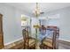 Bright dining room featuring a glass table, chandelier, and hardwood floors at 4115 34Th S Way # 195, St Petersburg, FL 33711