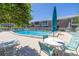 A refreshing community pool surrounded by lounge chairs, umbrellas and seating at 4115 34Th S Way # 195, St Petersburg, FL 33711
