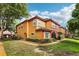 This is a sunny exterior view of a two-story condo building with a colorful paint scheme and green landscaping at 2272 Chianti Pl # 4-0048, Palm Harbor, FL 34683