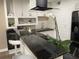 Modern kitchen with white cabinets, black countertops, and a stylish range hood at 224 6Th N Ave # 12, St Petersburg, FL 33701