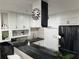 Modern kitchen with white cabinets, black countertops, and a stylish range hood at 224 6Th N Ave # 12, St Petersburg, FL 33701