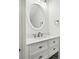 Updated bathroom with white vanity and a large round mirror at 2272 Chianti Pl # 4-0048, Palm Harbor, FL 34683