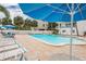 Refreshing community pool with blue umbrellas and lounge chairs at 19610 Gulf Blvd # 308, Indian Shores, FL 33785