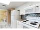 White kitchen features granite counters and tile floors at 19610 Gulf Blvd # 308, Indian Shores, FL 33785