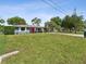 Charming house with red door, blue exterior, and a large front yard at 5425 Waters Edge Dr, New Port Richey, FL 34653