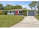 Newly renovated home with red door, blue exterior, and a well-manicured lawn at 5425 Waters Edge Dr, New Port Richey, FL 34653